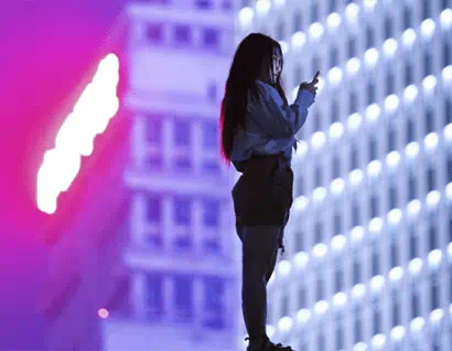 mujer mirando el mvil delante de un edificio alto