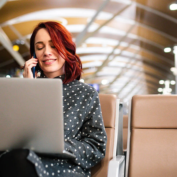 femme au tlphone assise avec un ordinateur portable dans le hall dentre