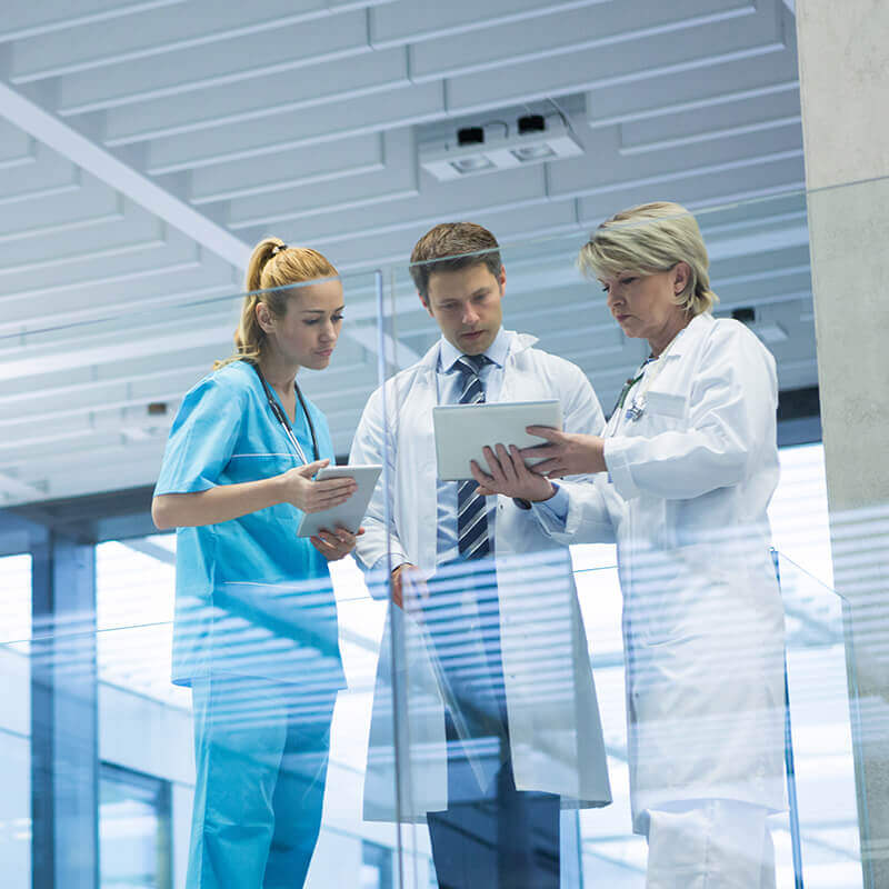 due medici e un'infermiera che guardano il tablet
